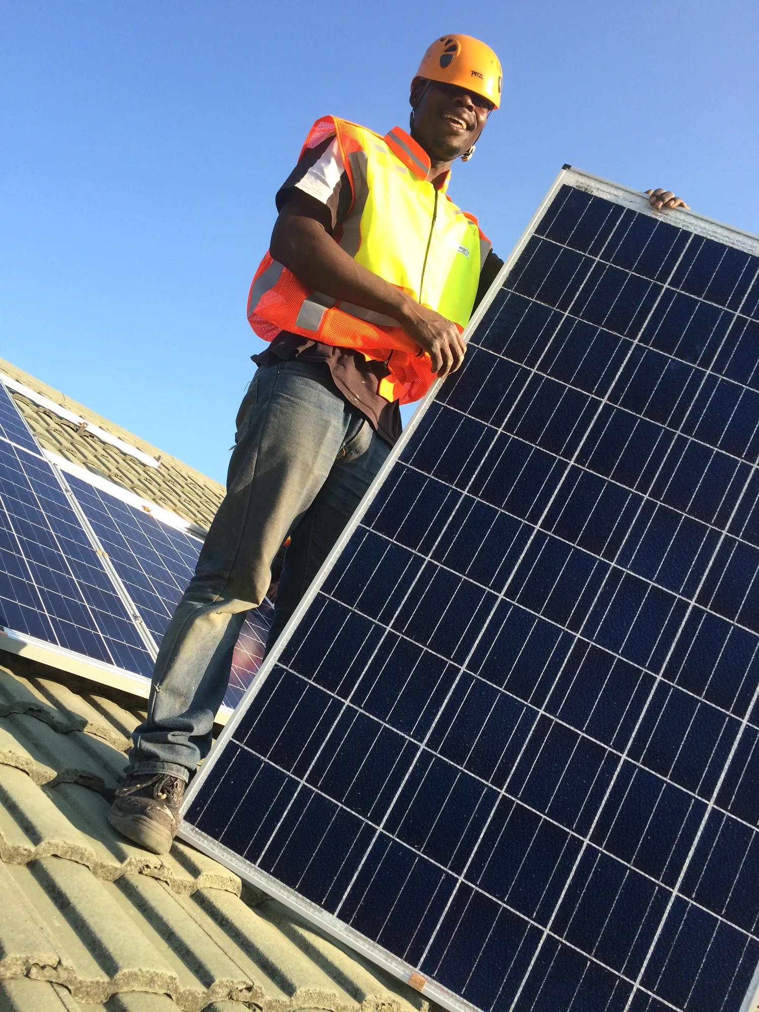 MSNT installer carrying a solar panel across a rooftop